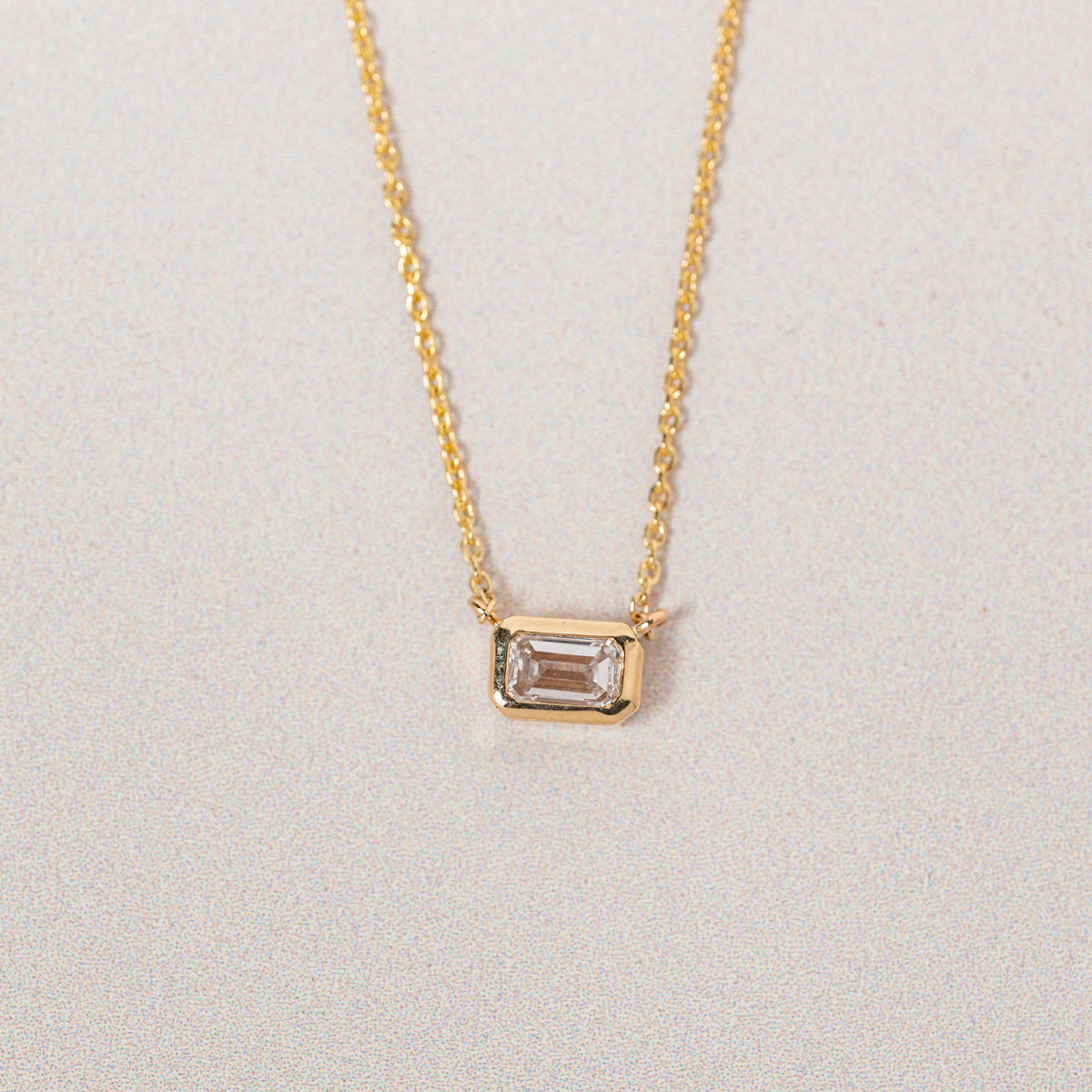14k yellow gold bezel set emerald cut lab grown diamond east west diamond pendant necklace