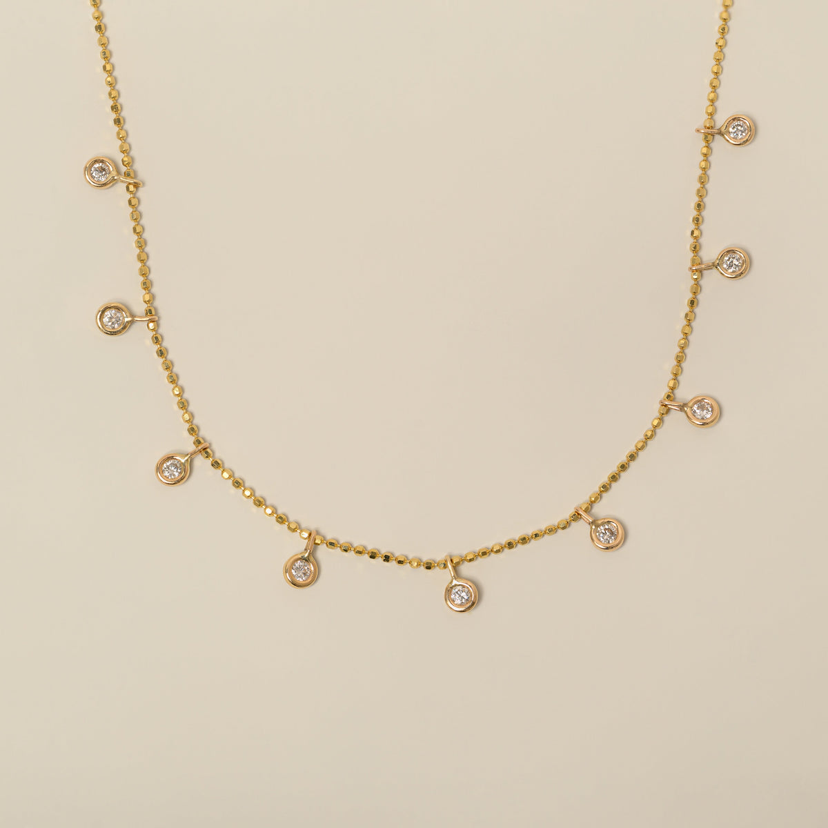 14k yellow gold bezel set diamond dangle station necklace on diamond bead cut chain