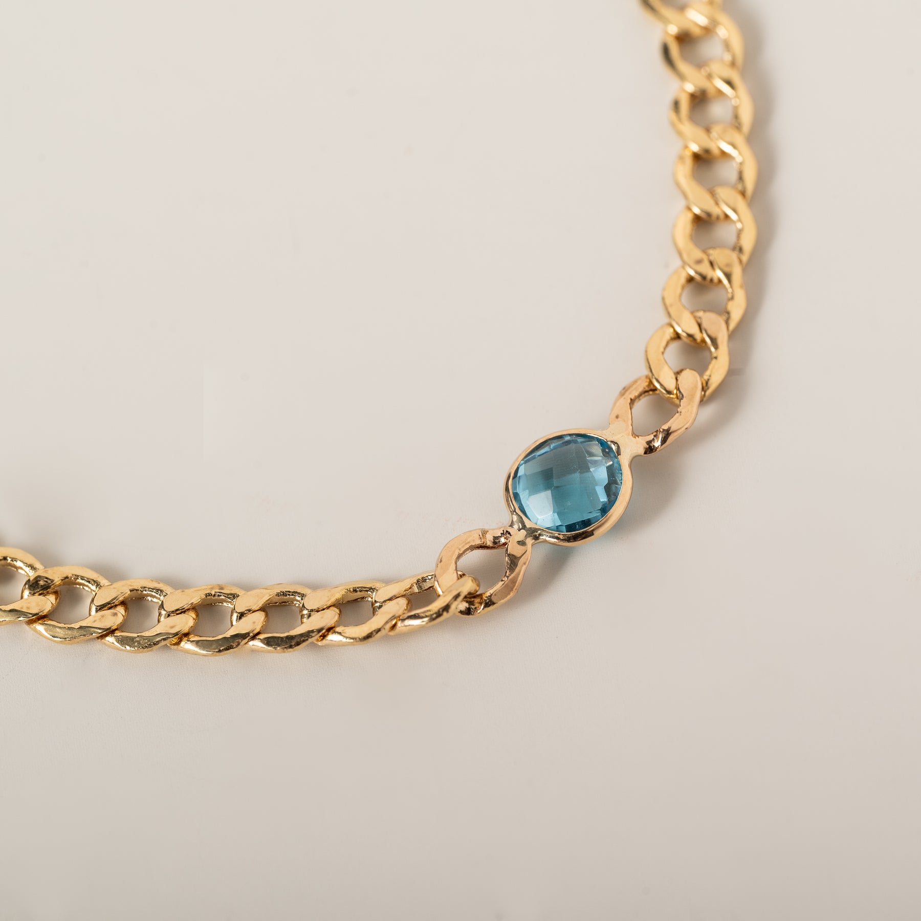 14k yellow gold curb chain bezel set round blue topaz bracelet
