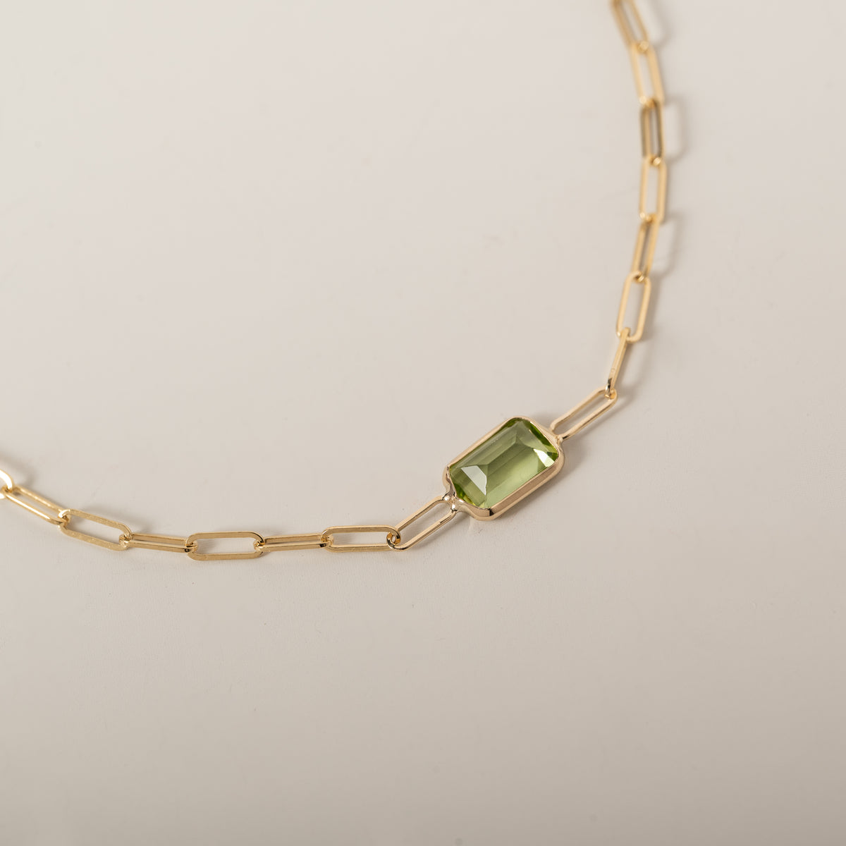 14k yellow gold emerald cut east west bezel set peridot paperclip chain bracelet