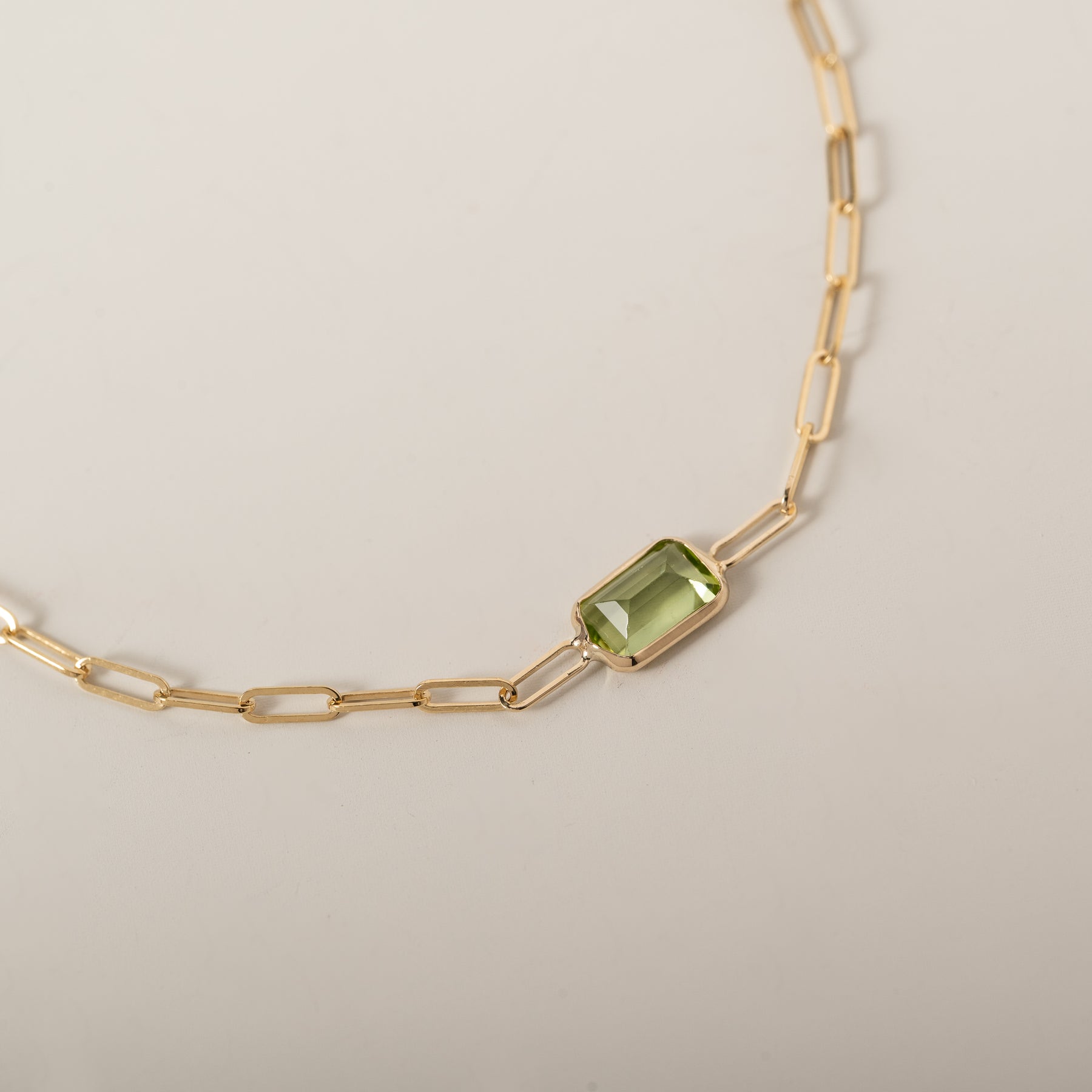 14k yellow gold emerald cut east west bezel set peridot paperclip chain bracelet