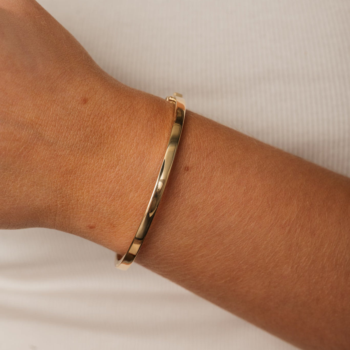14k gold flat 4mm plain bangle with hinge and safety clasp closure