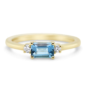 14k yellow gold three stone ring with 0.70ct emerald cut blue topaz and round cut diamonds