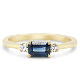 14k yellow gold three stone ring with 0.75ct emerald cut blue sapphire and two round cut diamonds