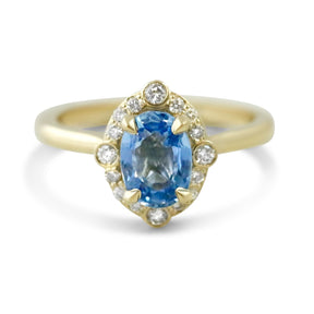 14k yellow gold oval light blue sapphire engagement ring with intricate diamond halo