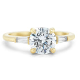 three stone semi-custom engagement ring with a round center stone and tapered baguette diamond side stones